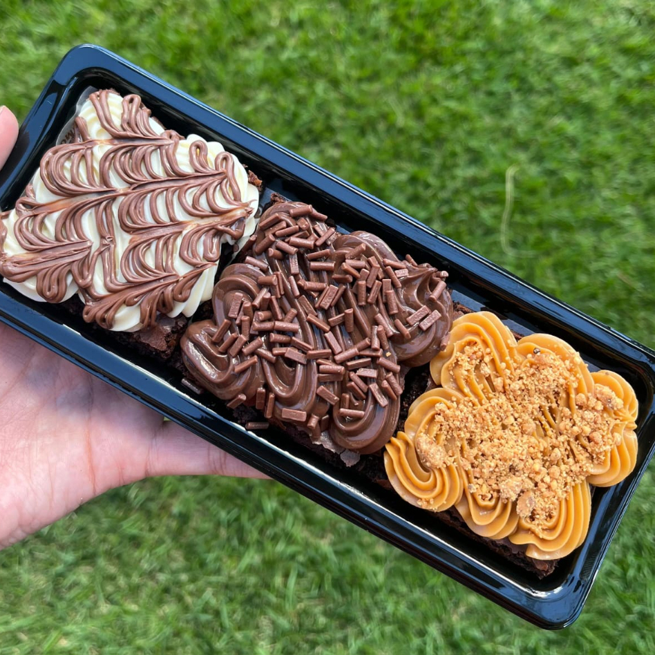 Brownies de massa úmida, densa e bem chocolatuda, com sabor intenso de chocolate de verdade 🍫 Coberturas irresistíveis: * Brigadeiro 50% + granulado premium crocante * Ninho cremoso com fio de Nutella * Doce de leite + finalização com paçoca Embalagem com tampa de acetato .