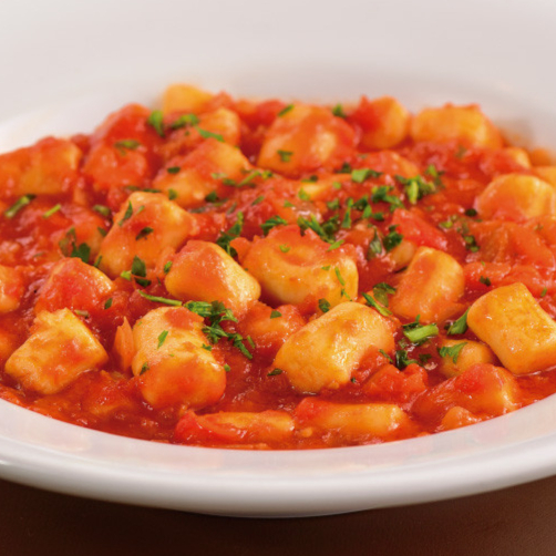 Nhoque Artesanal de Batatas, massa leve que desmancha na boca, acrescido de molho Pomodoro, e queijo parmesão à parte.
