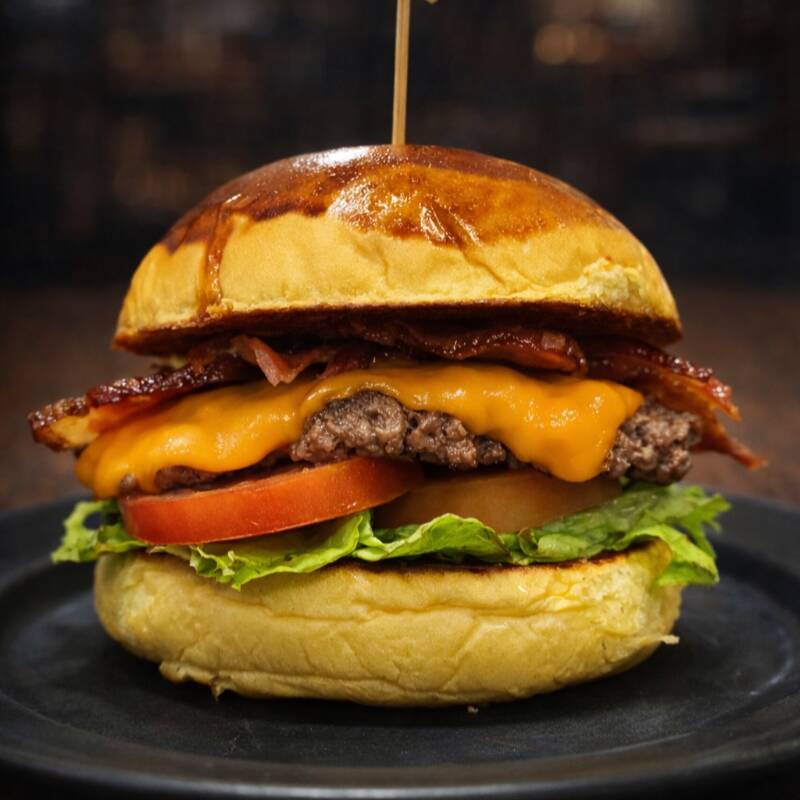 Pão brioche, burger 100g caseiro, cheddar, bacon, alface e tomate