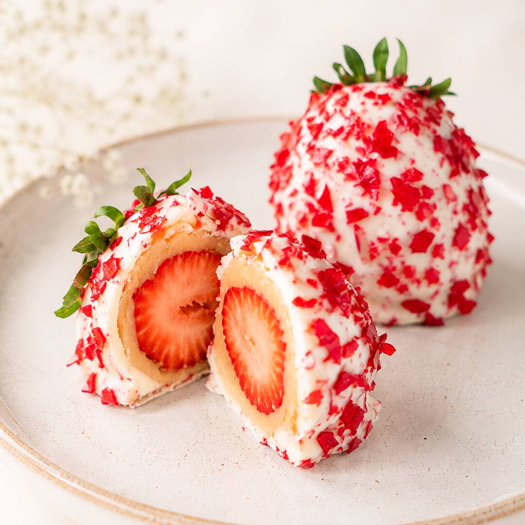 Morango Cravejado feito com morango selecionado, coberto com brigadeiro de Ninho, banhado em chocolate branco e finalizado com pedacinhos crocantes da calda do Morango do Amor.