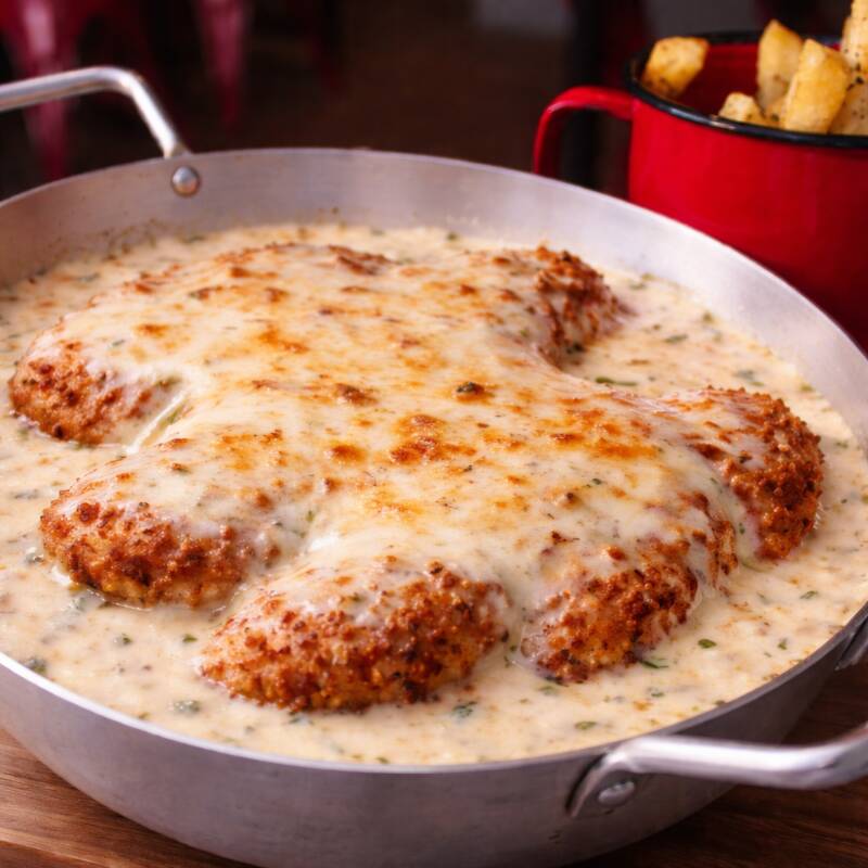 Filé mignon empanado e frito, coberto com com molho dois queijos (parmesão, nata e uma camada generosa de queijo mussarela derretido). Acompanha massa fettuccine na manteiga. Acompanha parmesão fresco ralado. Serve 2 pessoas. Aprox. 900g total