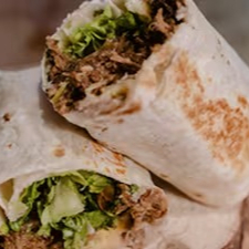 O 'Burrito de Pernil - Cholo' é uma vibrante homenagem à subcultura chicana que emergiu em Los Angeles, Califórnia, entre as décadas de 60 e 70. Este burrito é recheado e enrolado com um queijo derretido, alface crocante, Pico de Gallo - um vinagrete mexicano picante e refrescante - e Frijoles, uma rica pasta de feijão. A estrela do prato é a suculenta carne de Pernil desfiada, cozida lentamente até atingir a perfeição. Cada mordida deste burrito é uma explosão de sabores autênticos e texturas diversas, transportando você diretamente para a cultura vibrante e colorida da Califórnia.