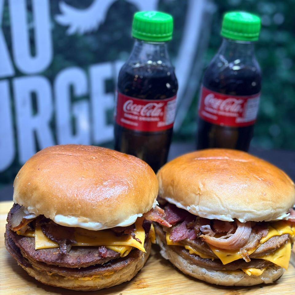 2 do nosso queridíssimo Triplex que vai com 3 Carnes de bife de Hambúrguer comum, 3 fatias de queijo cheddar, Bacon e molho especial, com 2 Cocas Pitchulinhas