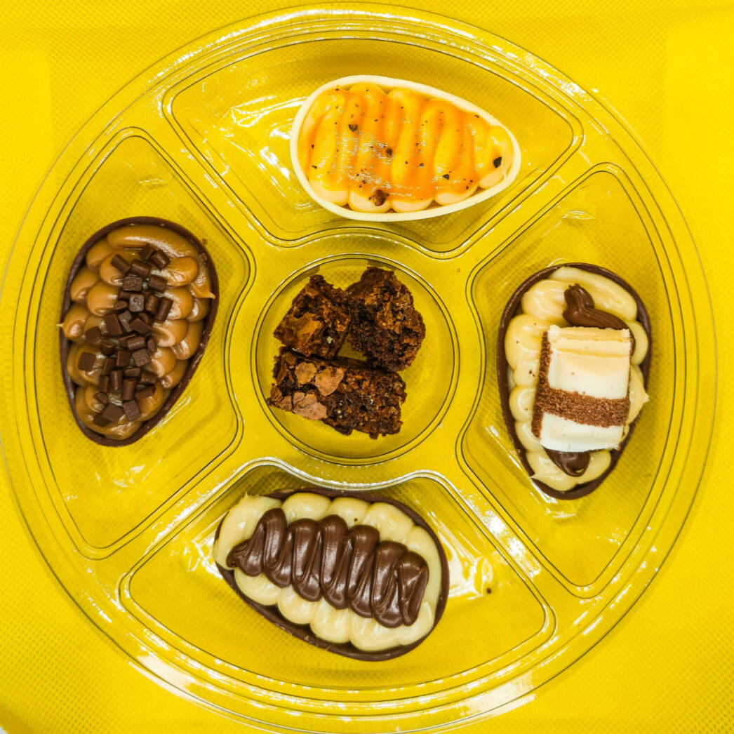 Petisqueira com mini ovos de colher 50g cada. Contém 4 unidades a sua escolha. As cascas podem variar entre chocolate ao leite ou chocolate branco, conforme o sabor e a disponibilidade. O doce do centro pode variar conforme disponibilidade (brownie ou uva) não sendo possível alterar.