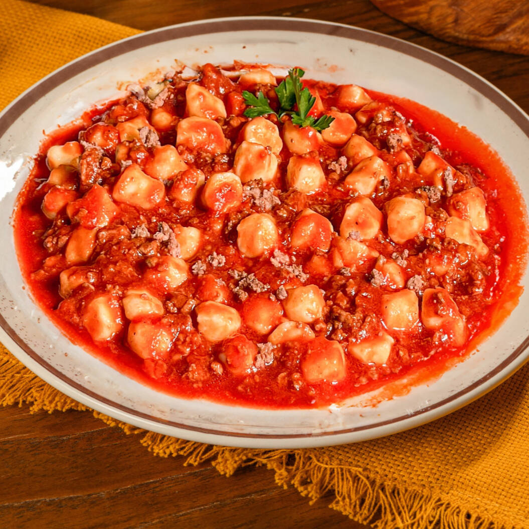 Nhoque de batata com molho bolonhesa feito com carne moída e tomate.