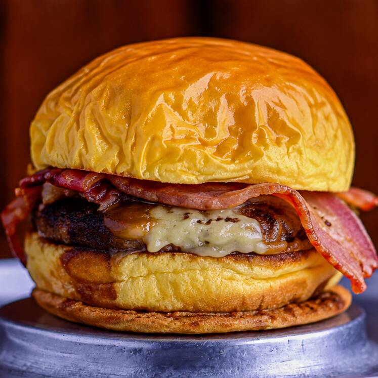 Pão brioche macio com hambúrguer artesanal de 100g, muçarela derretida, bacon crocante e molho da casa. Uma combinação suculenta, cremosa e irresistível.