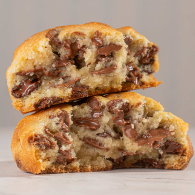 Nosso cookie de chocolate é feito com massa de baunilha e Muitas gotas de chocolate nobre ao leite e meio-amargo. Cada mordida é uma explosão de sabor: crocante por fora e macio por dentro.