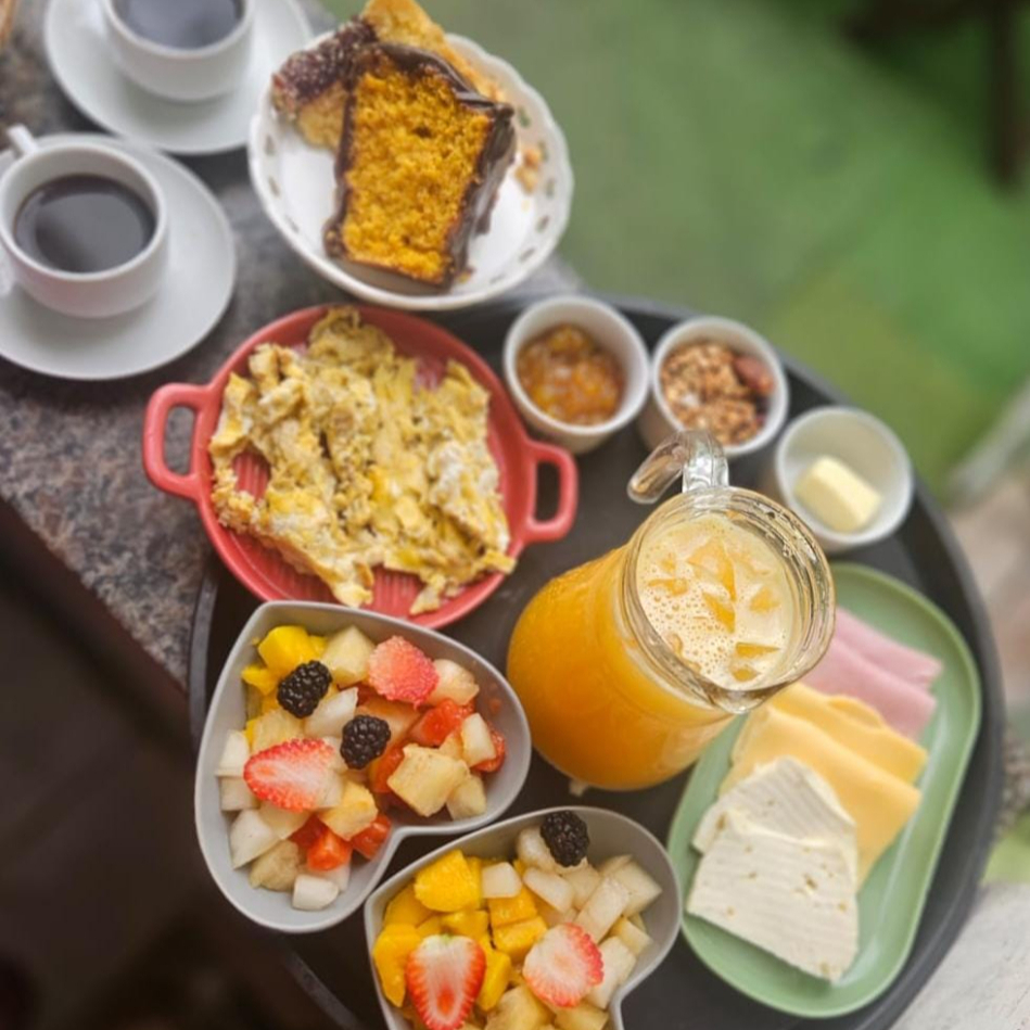 1 baguete, 2 franceses, 2 fatias de bolo, 150g frios, ovos mexidos, granola, geléia da casa, manteiga, suco 500ml, 2 saladas de fruta, 2 cafés 100ml (Acrescido das embalagens)