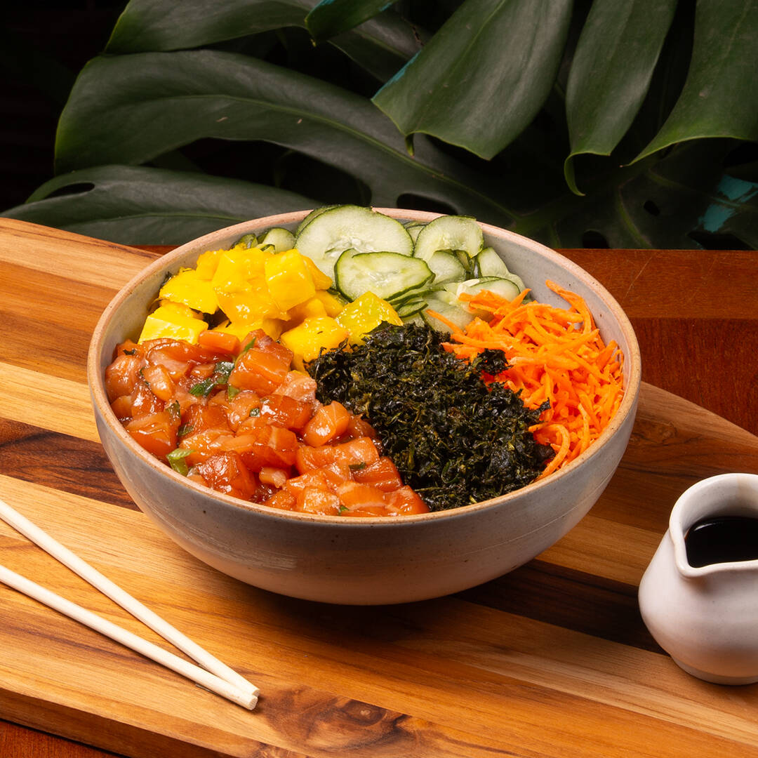 Salmão marinado ao perfeito estilo havaiano (à base de shoyo, óleo de gergelim e nosso tempero secreto - salmão marinado apresenta aroma mais intenso e aparência mais escura), arroz japonês temperado (shari), cenoura, manga, sunomono, crisp de couve e molho Let's Poke. Não é possível trocar nenhum ingrediente neste poke.