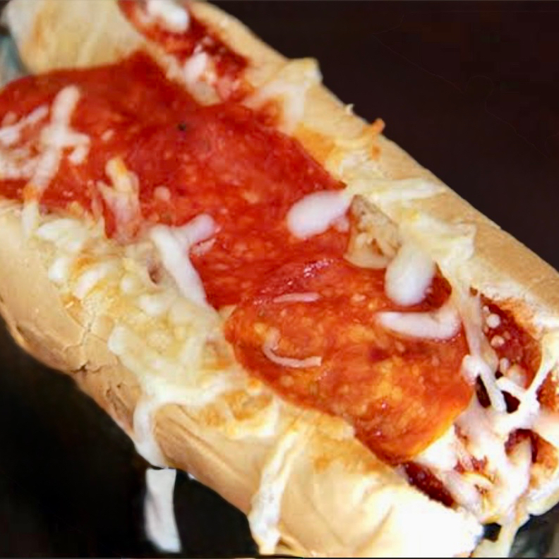 Pão de baguete com 2 salsichas catupiry cheddar purê e palha 8 rodelas de pepperoni todo enrolado no queijo prensado