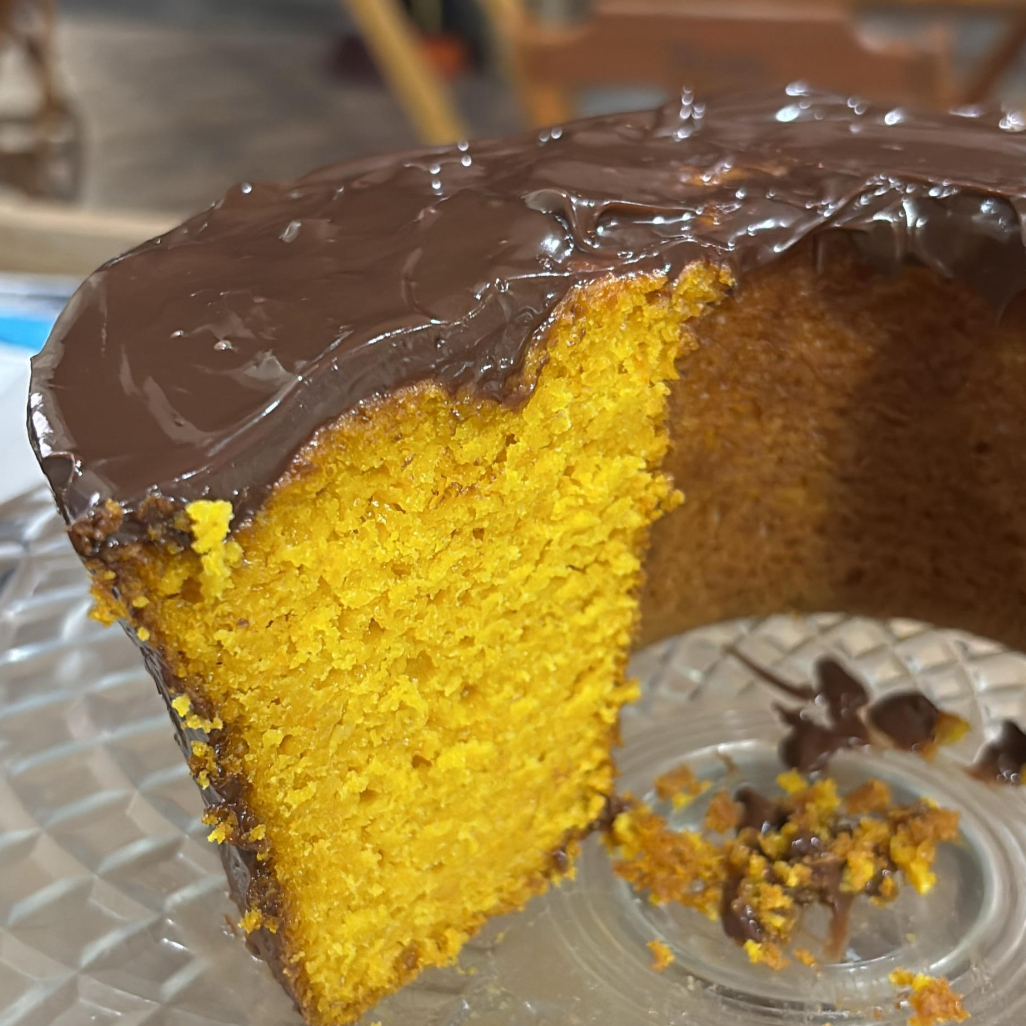 Fatia de bolo de cenoura com cobertura de chocolate, do jeitinho tradicional que a vovó fazia para o lanche.