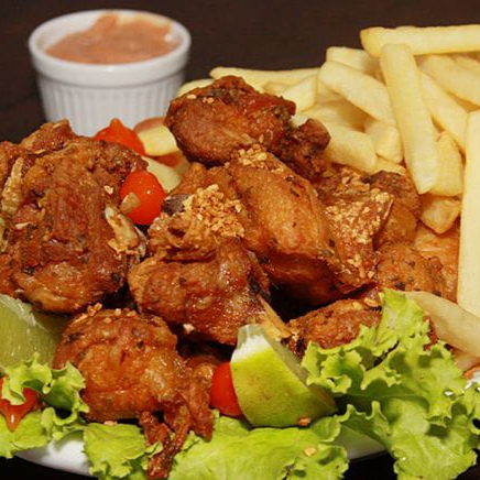 Porção de frango à passarinho com batata frita.