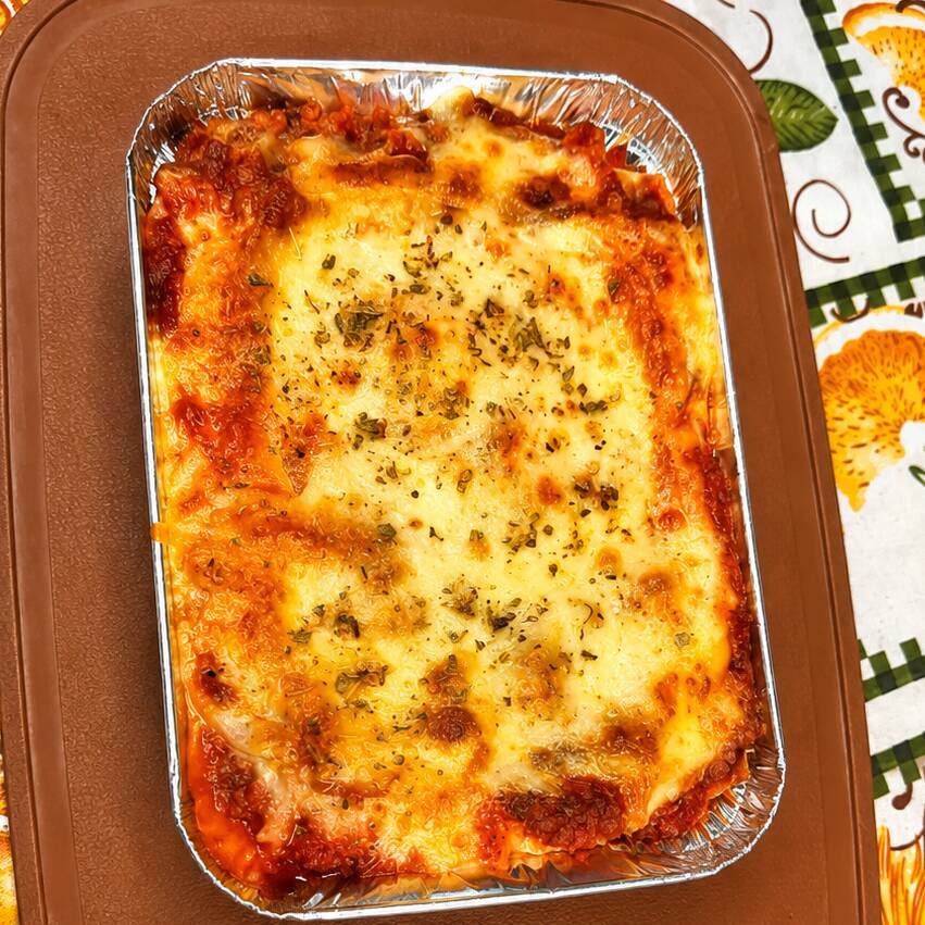 Lasanha tradicional com camadas de massa fresca, molho bolonhesa e queijo gratinado.