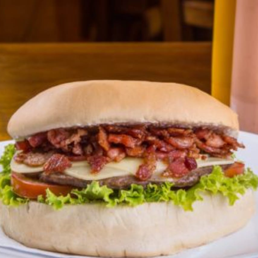 Pão gourmet, bacon, hambúrguer artesanal de 120 gramas, queijo, presunto, milho, ervilha, tomate, alface e maionese caseira