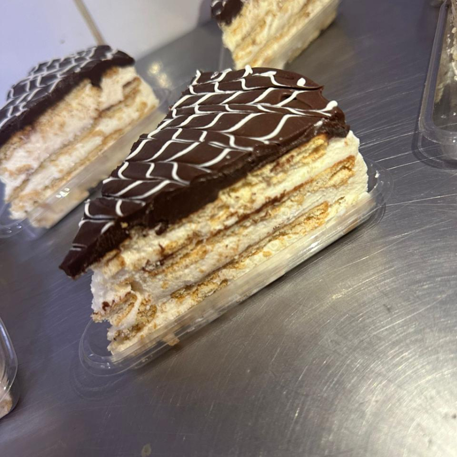 (duas camadas de creme branco sabor baunilha, biscoito amanteigado, ganache de chocolate e chocolate ao leite para decoração)