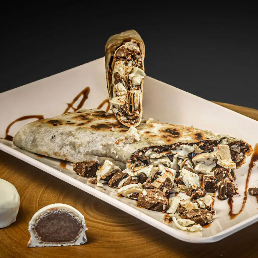 Pão sírio de 25cm recheado com pedaços de Ouro Branco, criando uma sobremesa única e deliciosa.