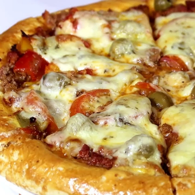 Molho de tomate, carne moída, presunto, mussarela e parmesão.