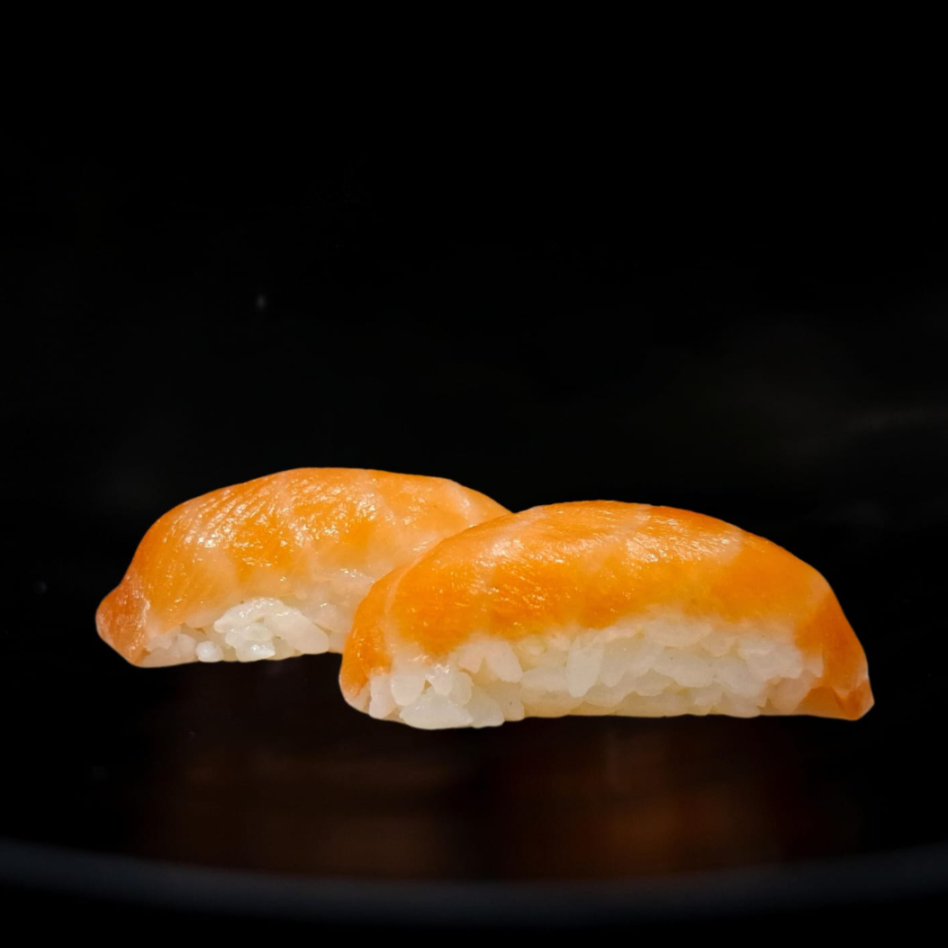 Bolinho de arroz com filé de salmão por cima. A porção deste item companha 1 molho shoyo (30ml)