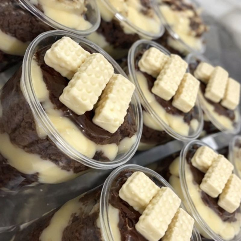 Camadas de brawnie, brigadeiro branco aerado, creme de Ninho aerado , finalizado com brigadeiro gourmet e um delicioso bis crocante