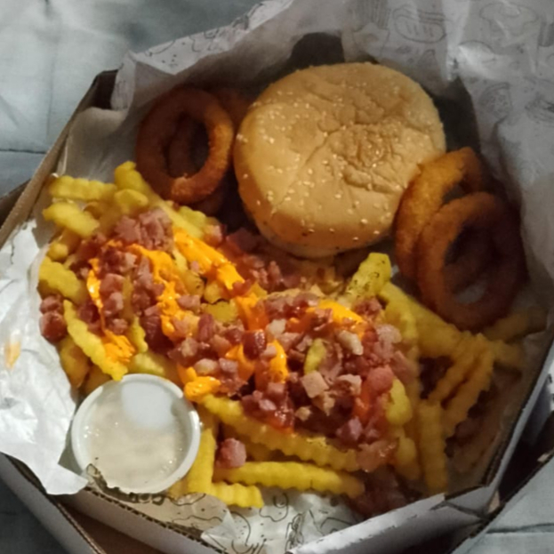 X Burguer Duplo, acompanhado de batata frita com bacon e cheddar, anéis de cebola, molho e um Guaravita