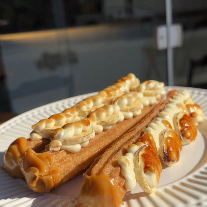 1 unidade de Churros Tradicional recheado com Doce de Leite e um irrestível recheio duplo de chocolate branco com banana caramelizada.