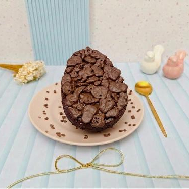 Ovo com casca de chocolate ao blend, recheado de brigadeiro de ninho, pasta crocante de Ovomaltine ,decorado com rocks Ovomaltine.