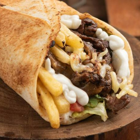 Pão sírio, carne, provolone, molho de alho, batata frita, tomate, alface e cebola roxa