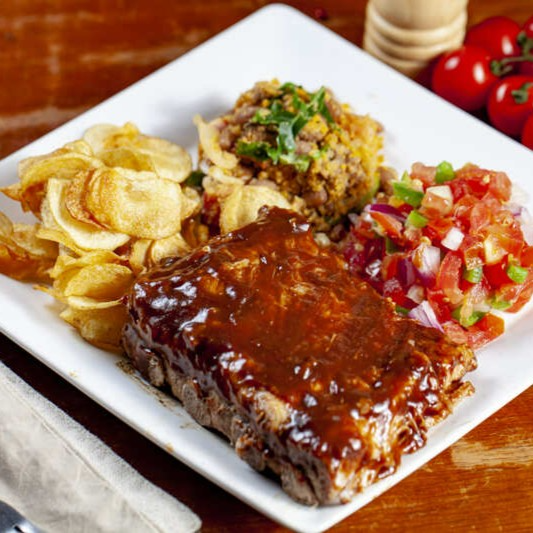 Sabor que derrete! Nossa costela suína é assada por 8 horas, garantindo uma textura que desmancha na boca. Servida com molho barbecue irresistível, escolha dois acompanhamentos e um molho para uma refeição completa