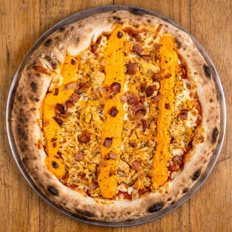 Massa fina artesanal, nosso molho de tomate da casa, muçarela, frango desfiado, bacon, cheddar e orégano.