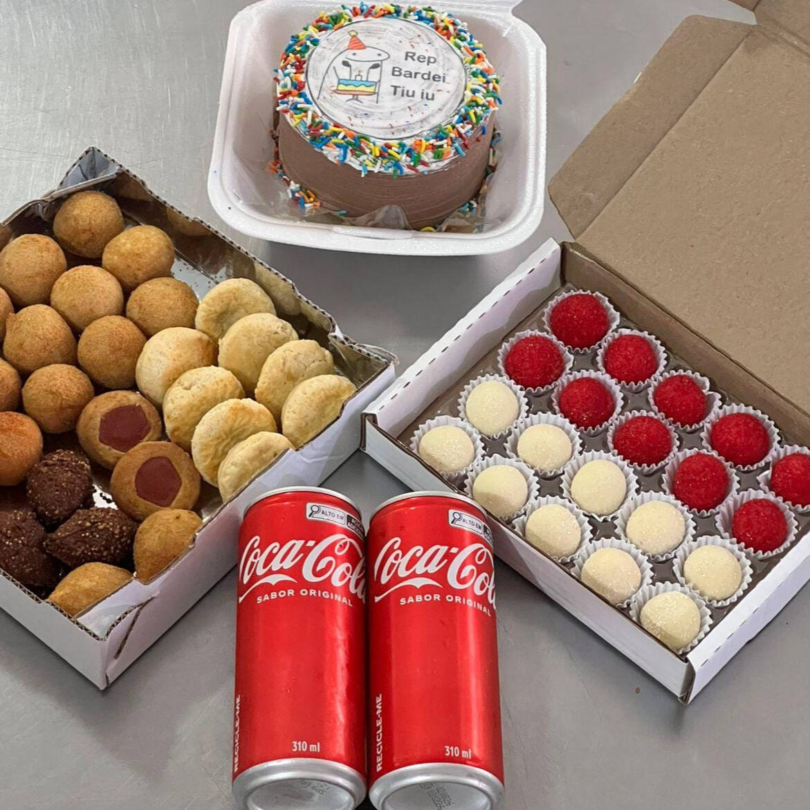 No kit vai 30 salgados, 20 doces,, 2 latas de refrigerante , 1 Bento Cake Ganache de Chocolate. Massa de Baunilha com recheio de Doce de Leite, de aniversário serve entre 2 pessoas (10cm de diametro) Aprox. 300g (produto mantido congelado, para segurança no transporte) Não personalizamos a decoração.