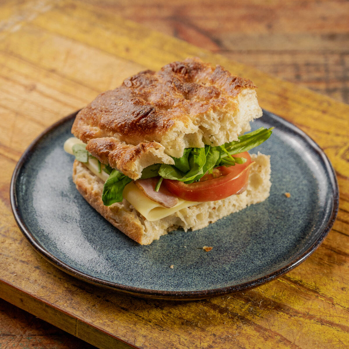 Lanche natural na massa de focaccia, com muçarela, Catupiry, presunto defumado, tomate e rúcula. (180g)