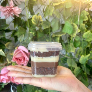 Bolo composto por massa de chocolate recheios de brigadeiro ao leite e brigadeiro branco