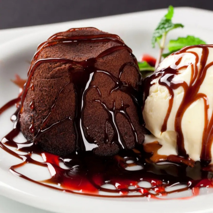 Bolinho de chocolate recheado com cobertura de chocolate e sorvete de creme.