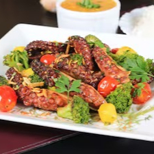 Porção de polvo grelhado ao alho e óleo, com brócolis e tomate cereja confitado. Acompanha arroz branco e pirão de peixe.