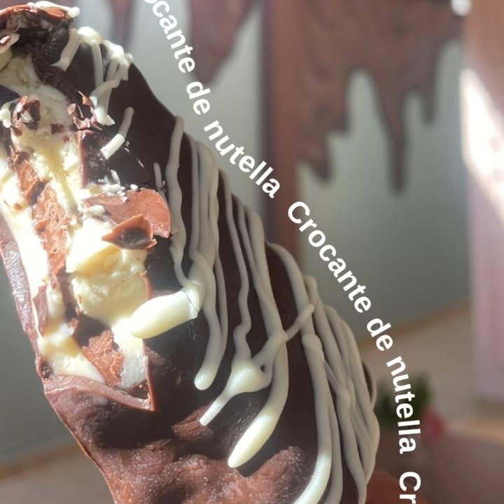 Um gelato cremoso de ninho, que combina perfeitamente com o recheio de nutella, criando uma experiência rica e indulgente. Finalizado com crocante e um toque de chocolate amargo, este gelato oferece uma textura única e um sabor equilibrado.