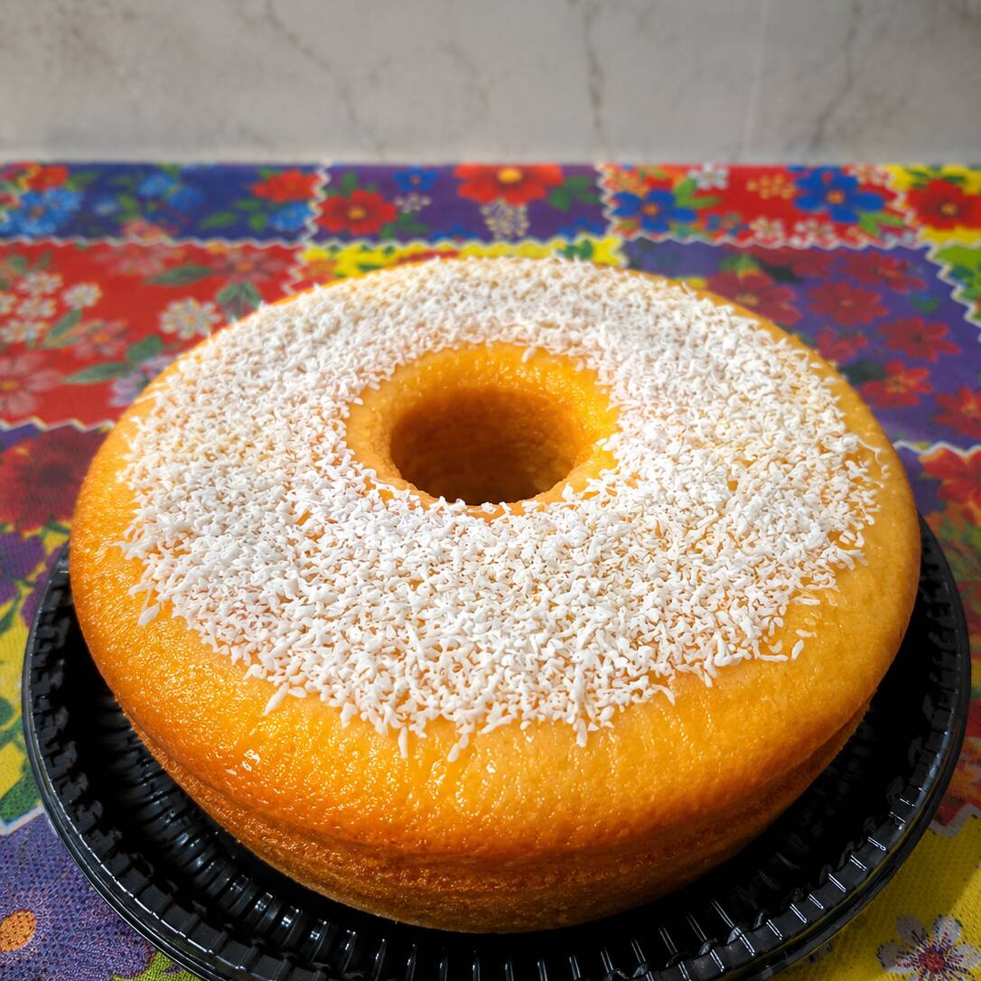 A combinação perfeita do sabor caseiro que você ama. Nosso bolo de milho é macio, úmido e coberto com uma deliciosa camada de coco ralado, feito com muito carinho para deixar seu café ainda mais especial.