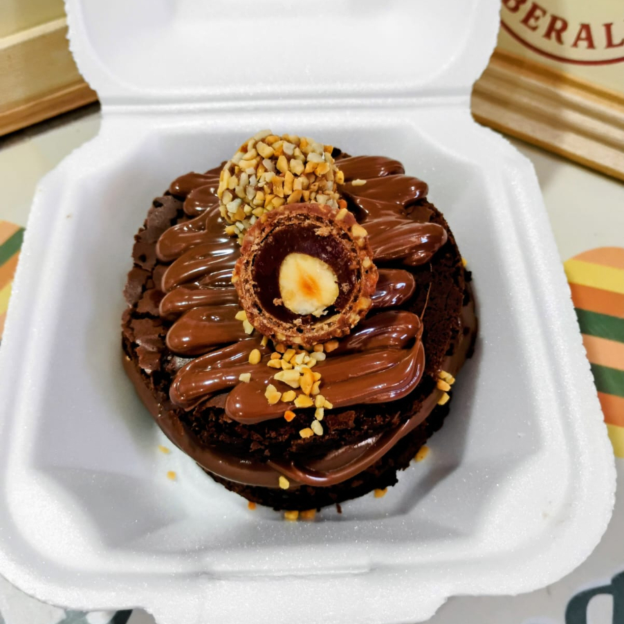 Duas camadas de brownie suculento, com recheio cremoso de chocolate com amendoim picado e Nutella original, finalizado com Nutella, brigadeiro, amendoim picado e Ferrero Rocher. Atenção, alérgicos: contém amendoim!