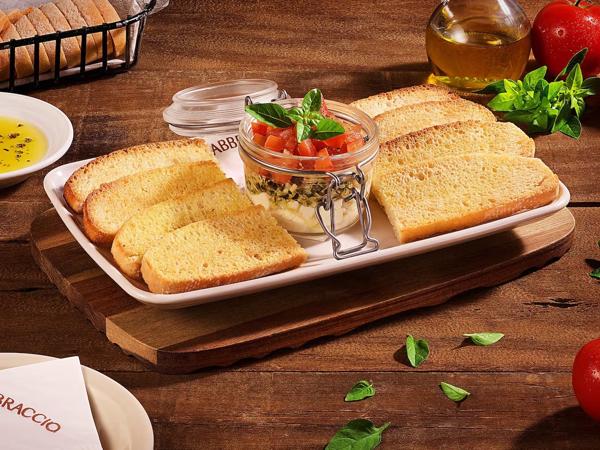 Ciabattas crocantes acompanhadas de queijo mozzarella fresca, tomates frescos em cubos e molho pesto caseiro.