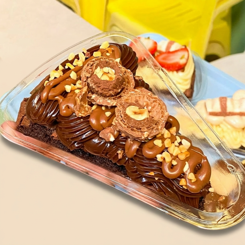 Uma fatia generosa do brownie artesanal da Santa Dopamina, macio por dentro e intenso em chocolate, finalizada com brigadeiro cremoso de cacau, Nutella, amendoim crocante e bombom Ferrero Rocher. Uma combinação premium, rica em chocolate e textura, feita para quem ama sobremesas intensas e irresistíveis. (Aqueça 30 segundos no microondas e surpreenda-se com esta delícia que vai alegrar seu Dia)