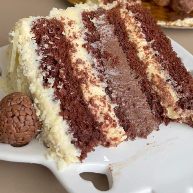 Fatia de torta com três camadas de chocolate: ao leite, branco e meio amargo. Cremosa, intensa e perfeita para os amantes de chocolate!