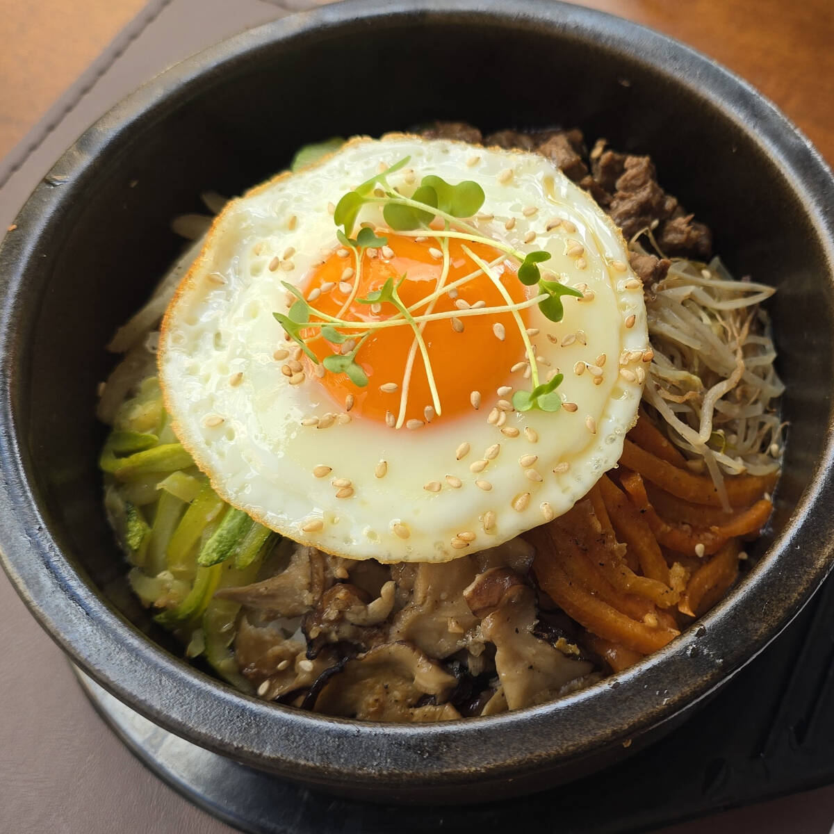 O Bibimbap é um prato coreano tradicional que combina arroz branco, legumes salteados, carne, ovo e o famoso molho apimentado gochujang. Além de sua apresentação vibrante, é amado pela mistura irresistível de sabores e texturas.