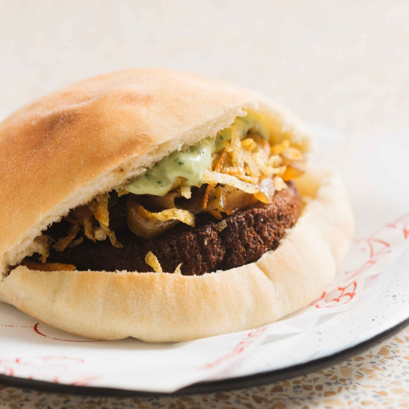 Burger de falafel, cebola caramelizada, batata palha da casa e maionese Pinati.