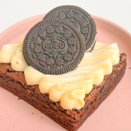 Brownie chocolatudo coberto com brigadeiro cremoso de leite Ninho e biscoito Oreo. tamanho 7x7cm
