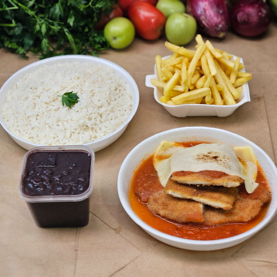 Nossa parmegiana ganha vida com um molho pomodoro artesanal, preparado no Brado Bar com tomates frescos de produtores locais e temperos naturais como salsão, salsinha e cebola. O resultado é um sabor caseiro e único, que envolve filé de frango empanado — crocante por fora, suculenta por dentro — e é finalizada com queijo gratinado. Acompanha: - Arroz temperado com cebola e alho (350 g) – Marmita P - Feijão do Dia (250 ml) – Potinho lacrado - Batata frita crocante (120 g) – Marmitinha H3 - Carne à Parmegiana (300 g) – Marmita M ** Serve de 1 a 2 pessoas.