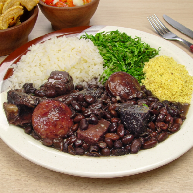 Feijão preto bem temperado, carnes suínas macias paio, calabresa, costelinha e carne seca, arroz soltinho, couve refogada na manteiga, farofa temperada, torresmo. (tudo na mesma marmita). Tudo embalado com carinho pra chegar na sua casa quentinho, saboroso e pronto pra matar a sua fome.