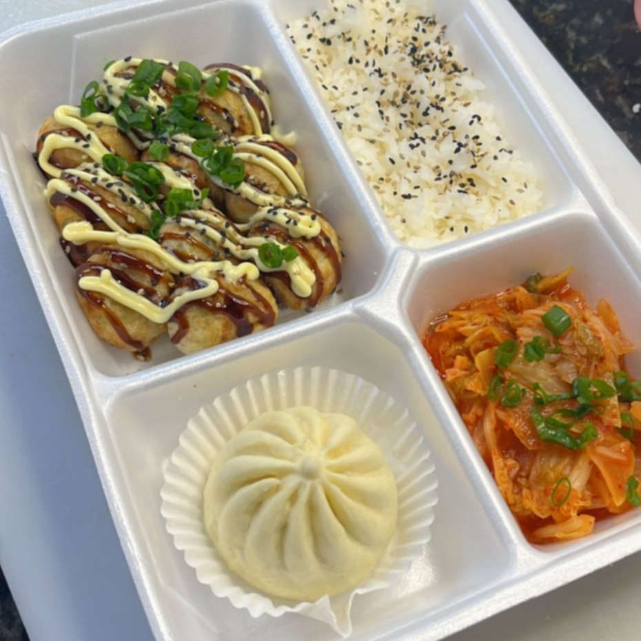 Que tal um prato quentinho hoje? Uma porção de 10 takoyakis, uma deliciona massinha recheada com polvo finalizada com tarê maionese, cebolinha e gergelim, acompanha uma porção de gohan quentinho, uma porção de kimchi e um nikuman de frango