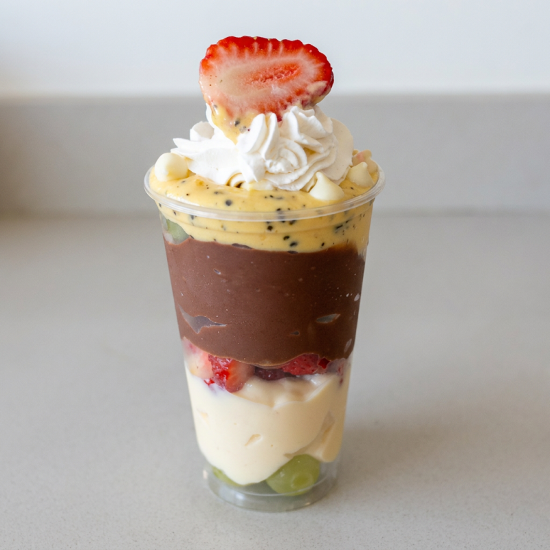 Chegou Novidade! É o Copo Tropical! Com creme de chocolate branco e preto, mousse de maracujá, uva e morangos picados e finalizado com chantilly.