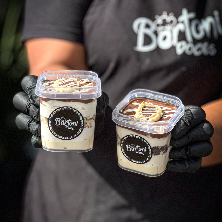 Mousse de Ninho suave, creme de Ninho, Ouro Branco picado, finalizado com ganache de chocolate nobre, meio bombom, e risquinhos de chocolate branco. Novo tamanho: 220ml. Obs.: a Bertoni Doces não altera nenhum produto ou retira/adiciona ingrediente.