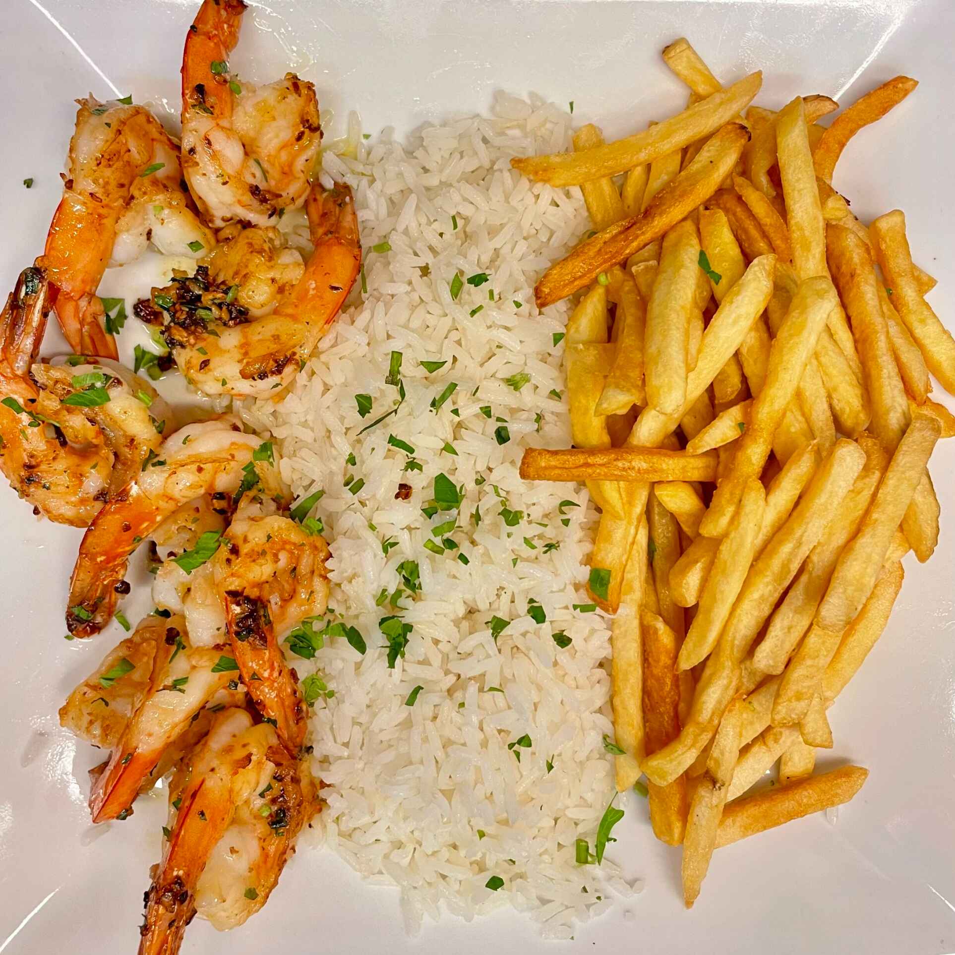Prato com arroz soltinho, feijão com caldinho, camarão alho e óleo estilo praia, acompanhado de fritas crocantes
