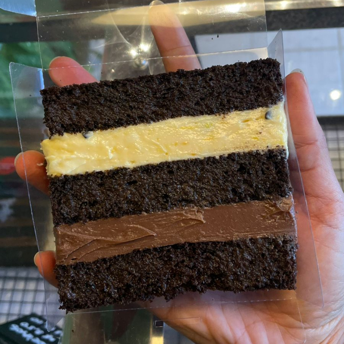 Massa com cacau black, brigadeiro 50% e creme trufado de maracujá. Fatia com aprox.160,0g